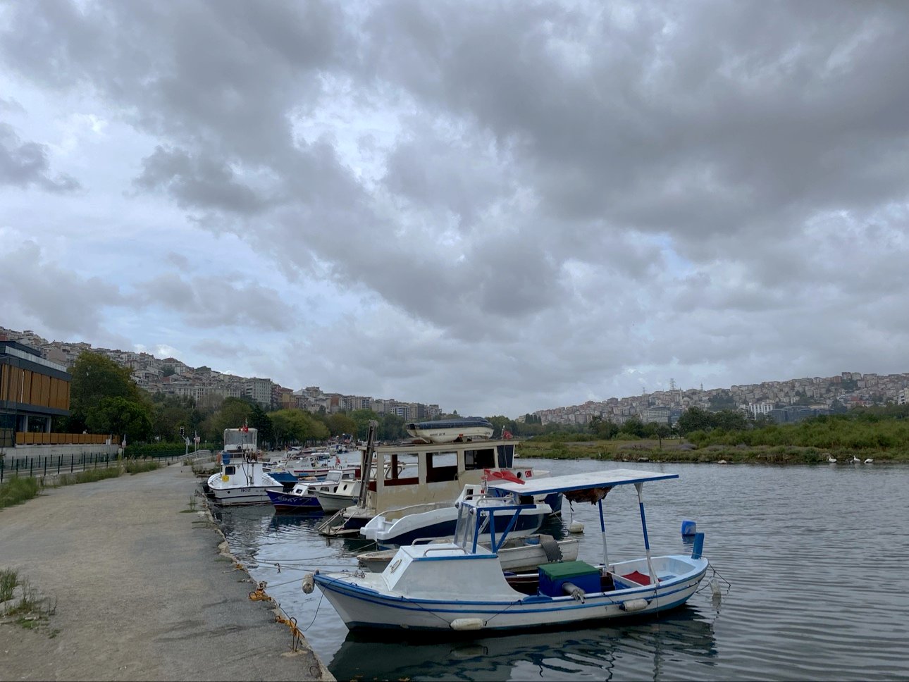 Fishing boats moored on grey water under a heavy sky